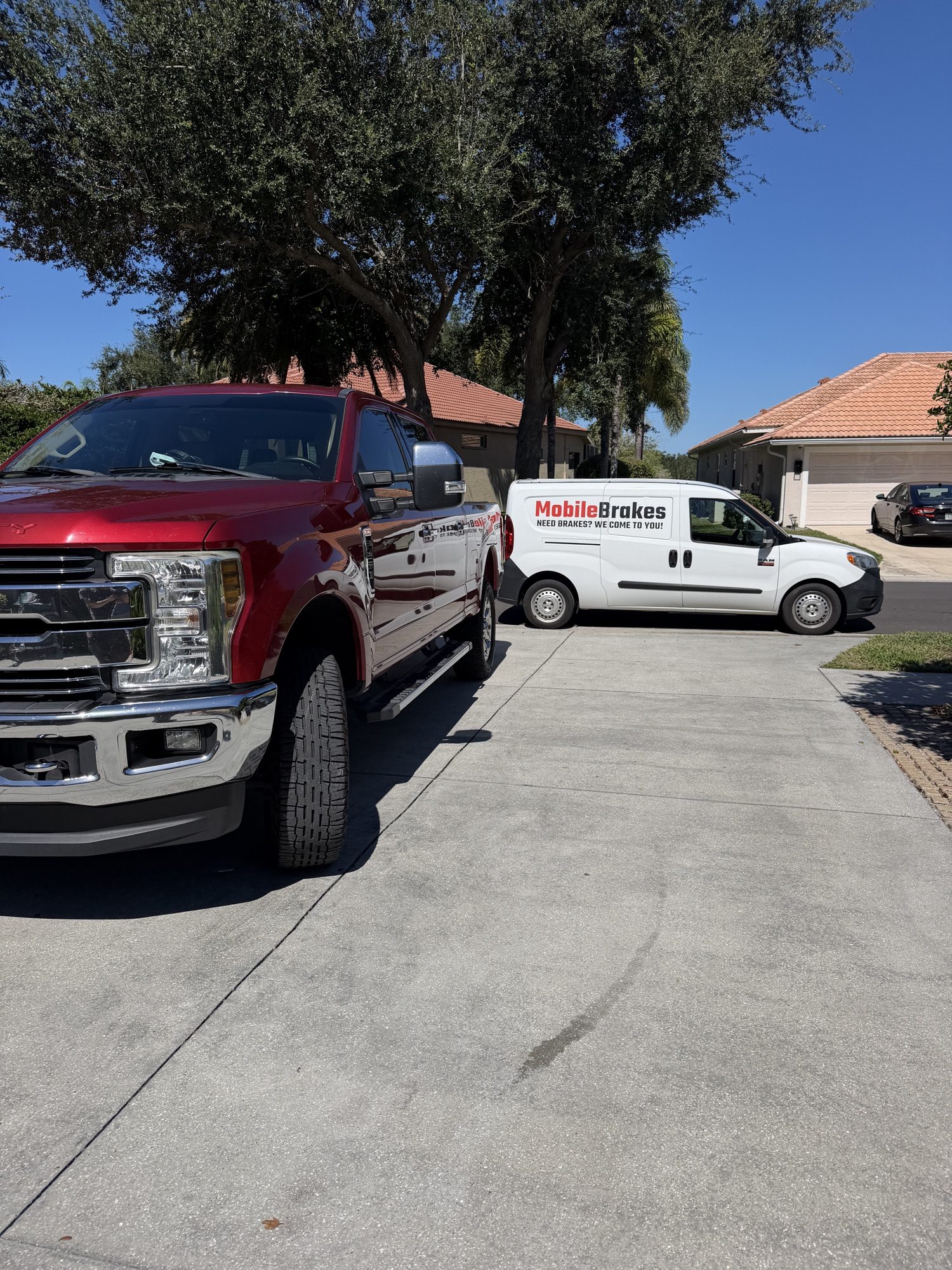 Mobile Brakes work van beside a pickup truck at a Sarasota home